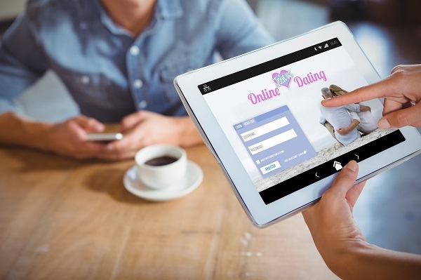 Online Dating App Against Person Using Tablet Computer In Cafe